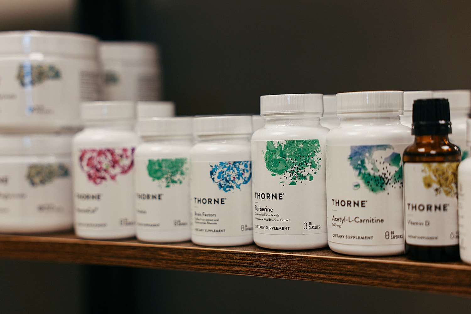 Dietary supplements arranged on a wooden shelf.