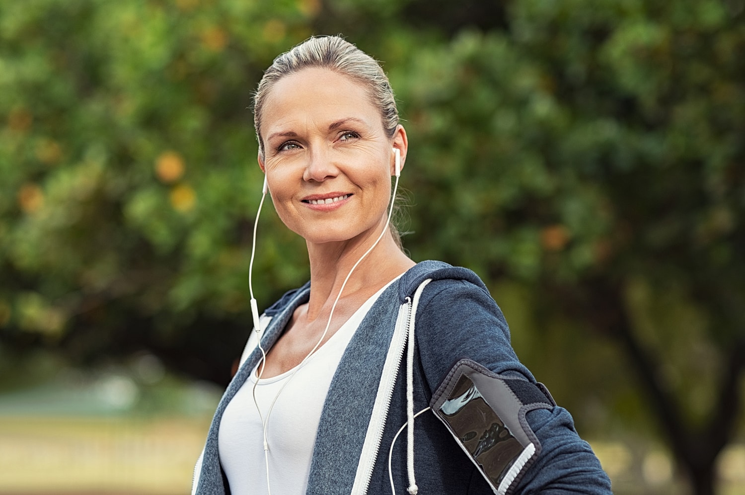 Smiling woman holding a jump rope outdoors.