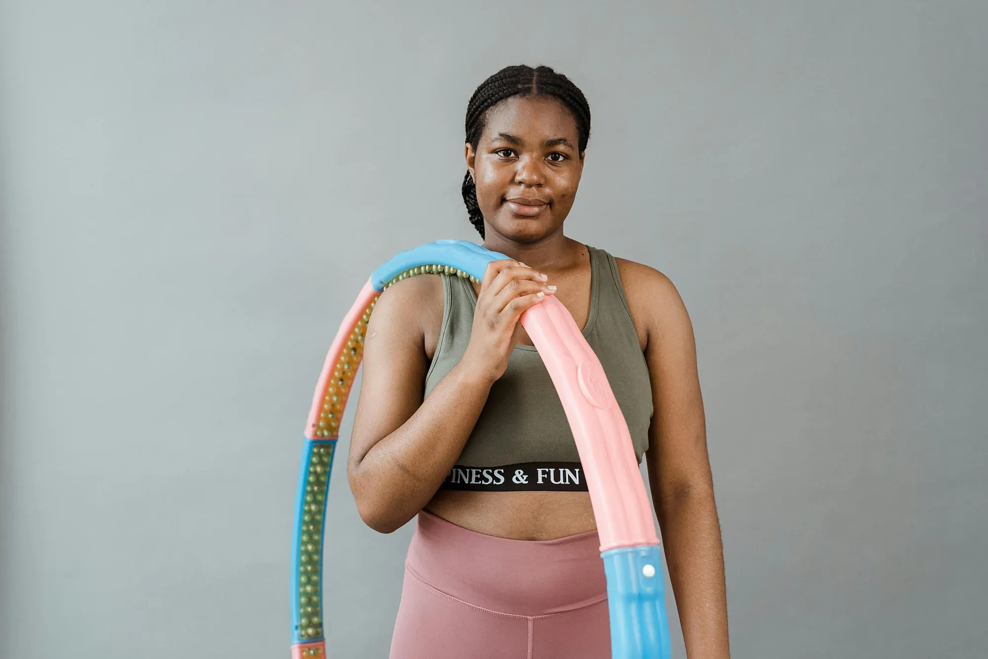 Person holding a colorful hula hoop indoors.